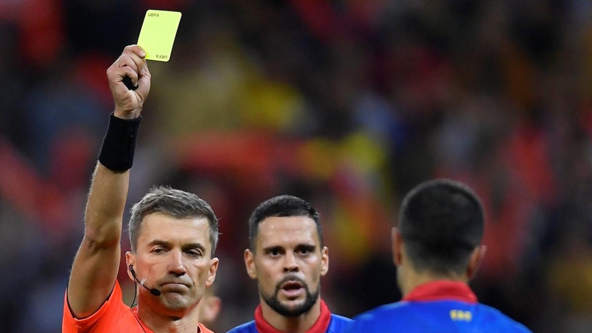 Estonian referee Kristo Tohver shows a card